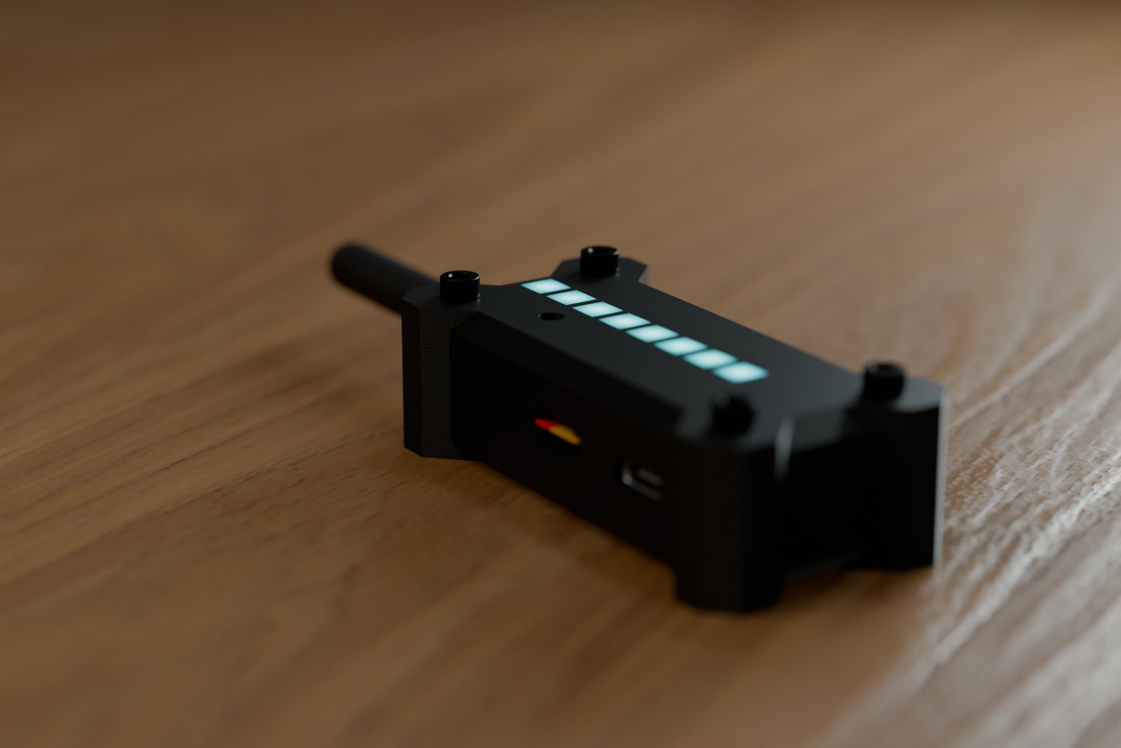 SignalSweep in its black case on a wooden table, LED bar lit cyan, antenna attached